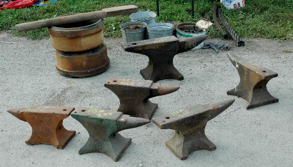 A stack of used anvils for sale.