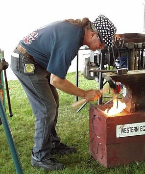 Frank Turley forming a spoon on a wood surface.